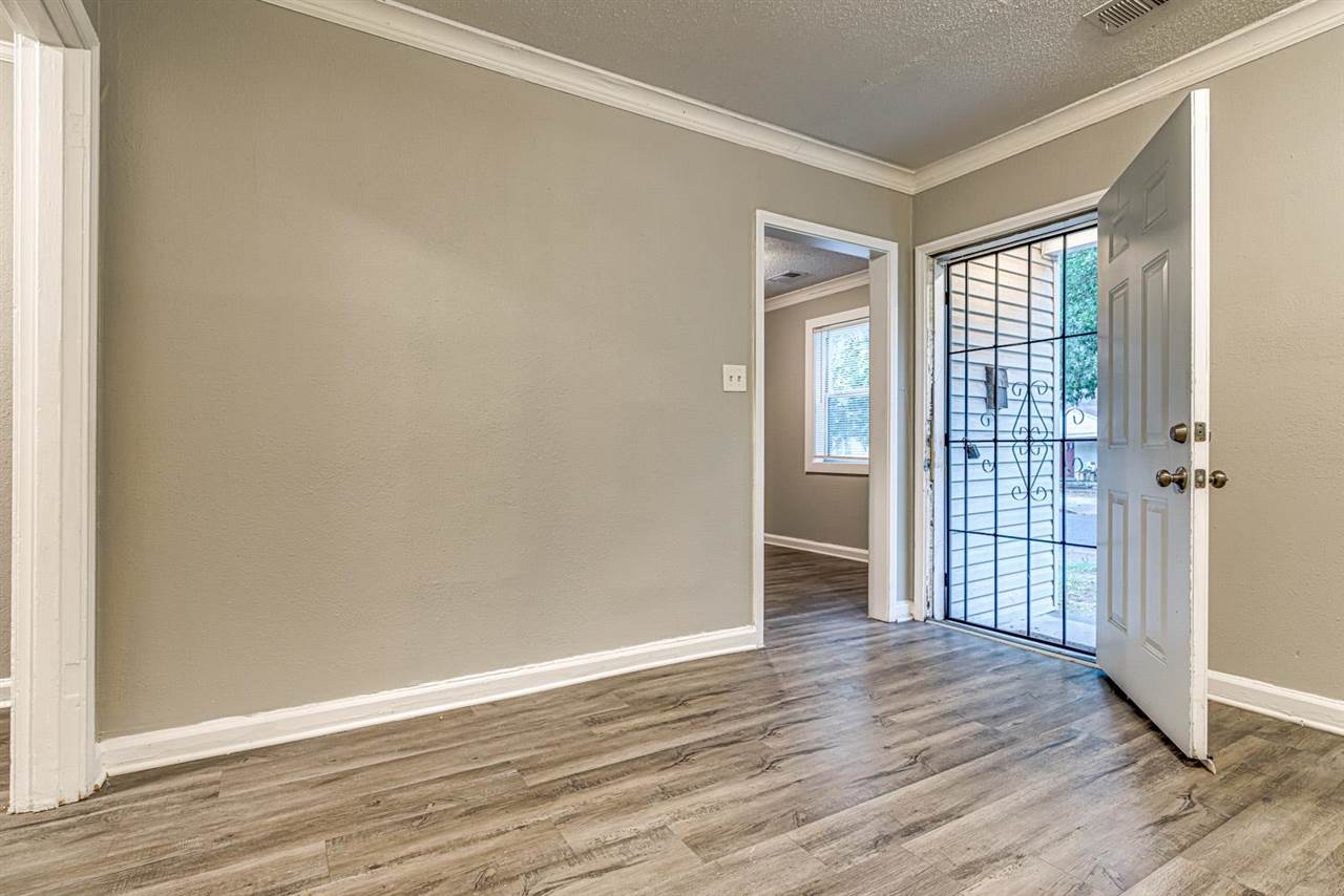 1023 Parkland Road Memphis, TN 38111 - Photo 6 of 22 a view of an empty room with wooden floor and a window