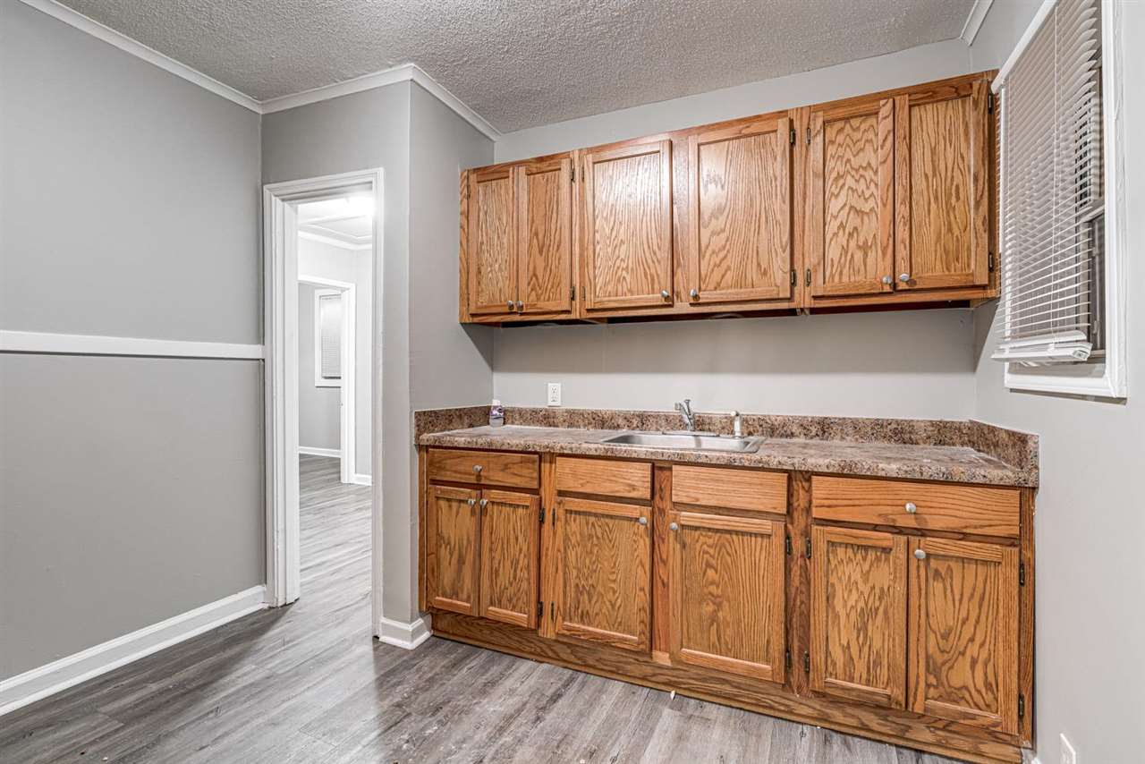 1023 Parkland Road Memphis, TN 38111 - Photo 9 of 22 a kitchen with granite countertop wooden cabinets and sink