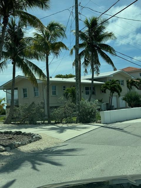 351 Stirrup Key Boulevard Marathon, FL 33050 - Photo 18 of 21 a view of a house with a yard and palm trees