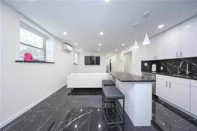 a dining room with stainless steel appliances furniture a rug and a kitchen view