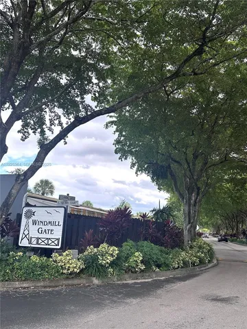 a view of a street sign under a large tree