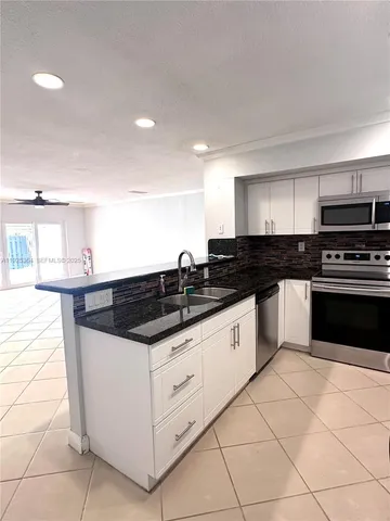 a kitchen with granite countertop a sink and a stove