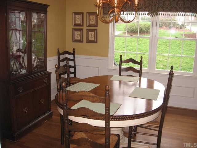 901 Tyrrell Road Raleigh, NC 27609 - Photo 5 of 12 a view of a dining room with furniture a chandelier and wooden floor