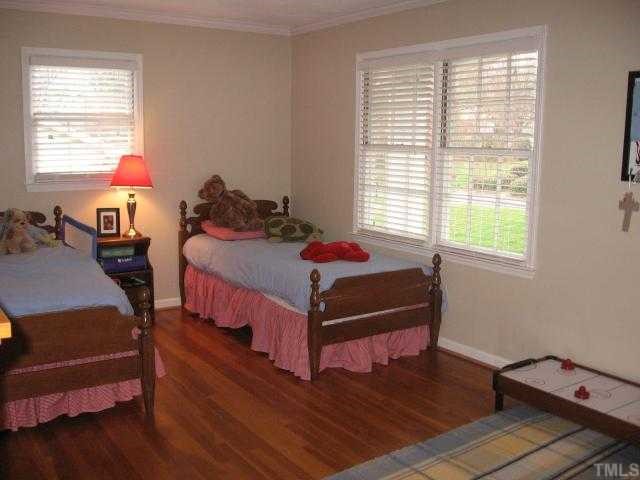 901 Tyrrell Road Raleigh, NC 27609 - Photo 10 of 12 a bedroom with a bed and wooden floor