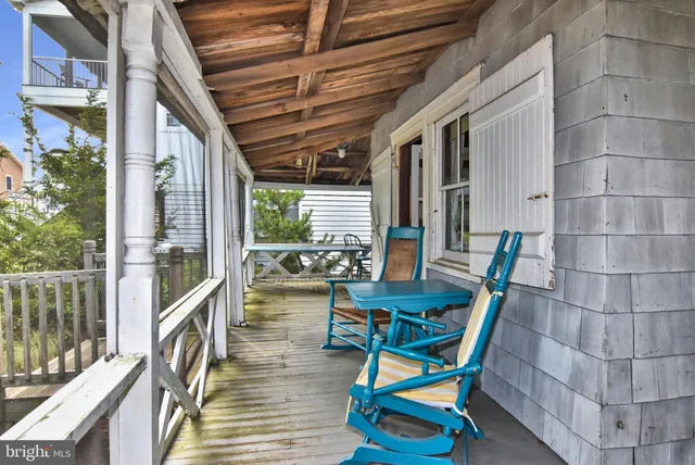 a roof deck with table and chairs and wooden floor