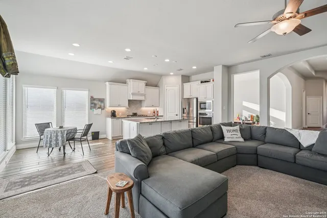 a living room kitchen with furniture and a large window