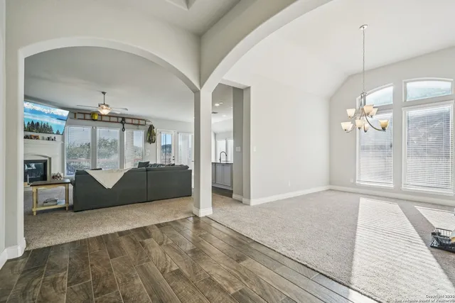 a view of a big room with windows and chandelier