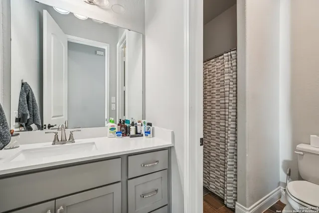 a bathroom with a sink a toilet and shower