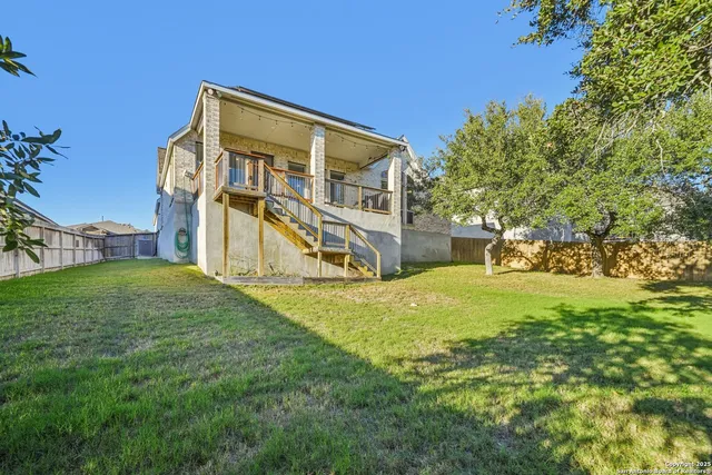 a view of an house with backyard and a tree