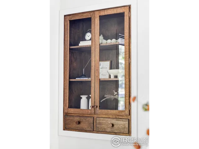 a view of a hallway with cabinet and mirror