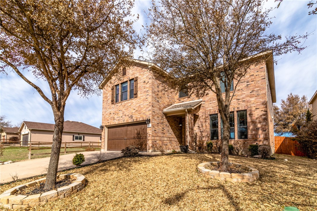 a front view of a house with a yard covered with snow and trees