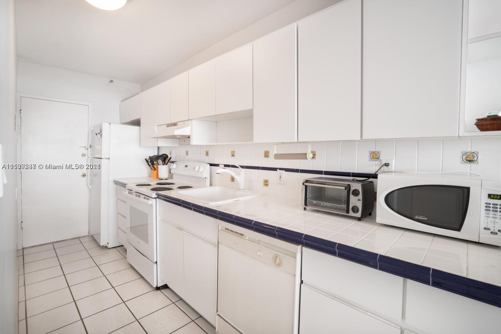 100 Lincoln Road, Unit 406 Miami Beach, FL 33139 - Photo 4 of 10 a kitchen with cabinets and white appliances