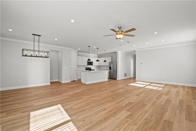 a view of a room with wooden floor chandelier and windows