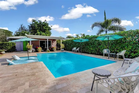a view of a house with swimming pool and sitting area