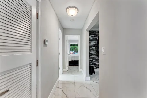 a view of a hallway with entryway and chandelier