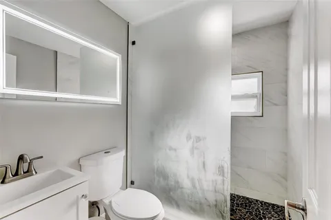 a white toilet sitting next to a bathroom sink