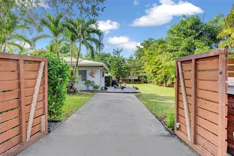 front view of a house with a yard and potted plants
