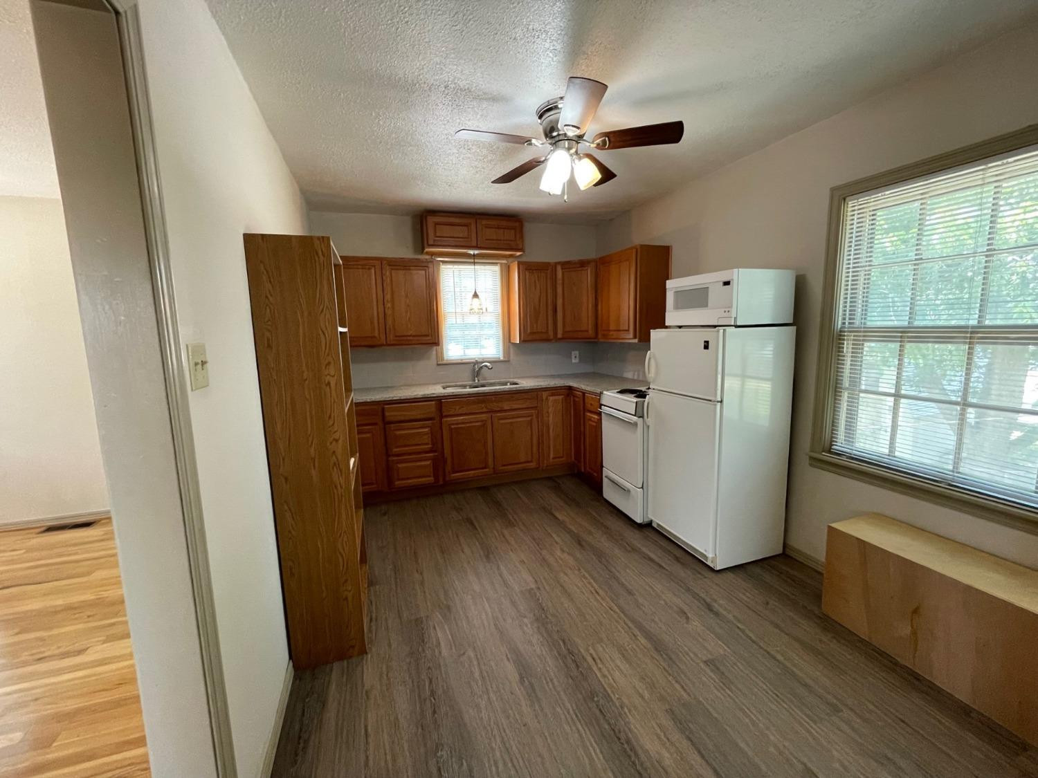 3018 29th Street Lubbock, TX 79410 - Photo 10 of 14 a kitchen with cabinets a refrigerator and a window