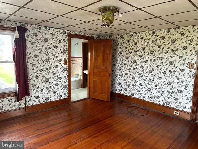 a view of a room with wooden floor and a window