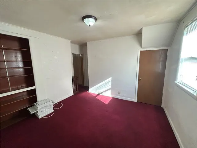 a view of an empty room with wooden floor and windows