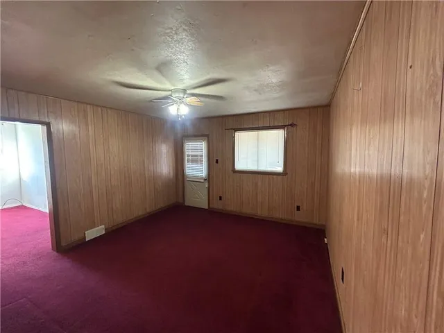 an empty room with windows and closet area