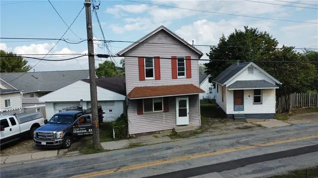 a front view of a house with cars parked