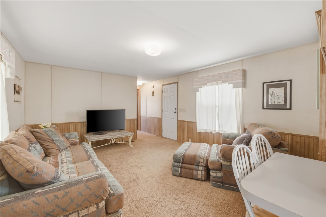 3880 Rising Sun Road Bullhead City, AZ 86442 - Photo 11 of 42 Living area with wood-finish wainscoting, light-toned walls, and a textured carpet