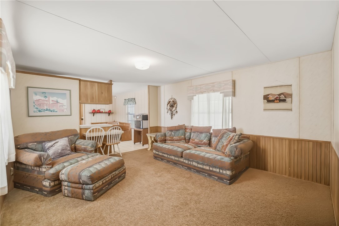 3880 Rising Sun Road Bullhead City, AZ 86442 - Photo 12 of 42 Carpeted living area with light-toned walls and wood-panel wainscoting