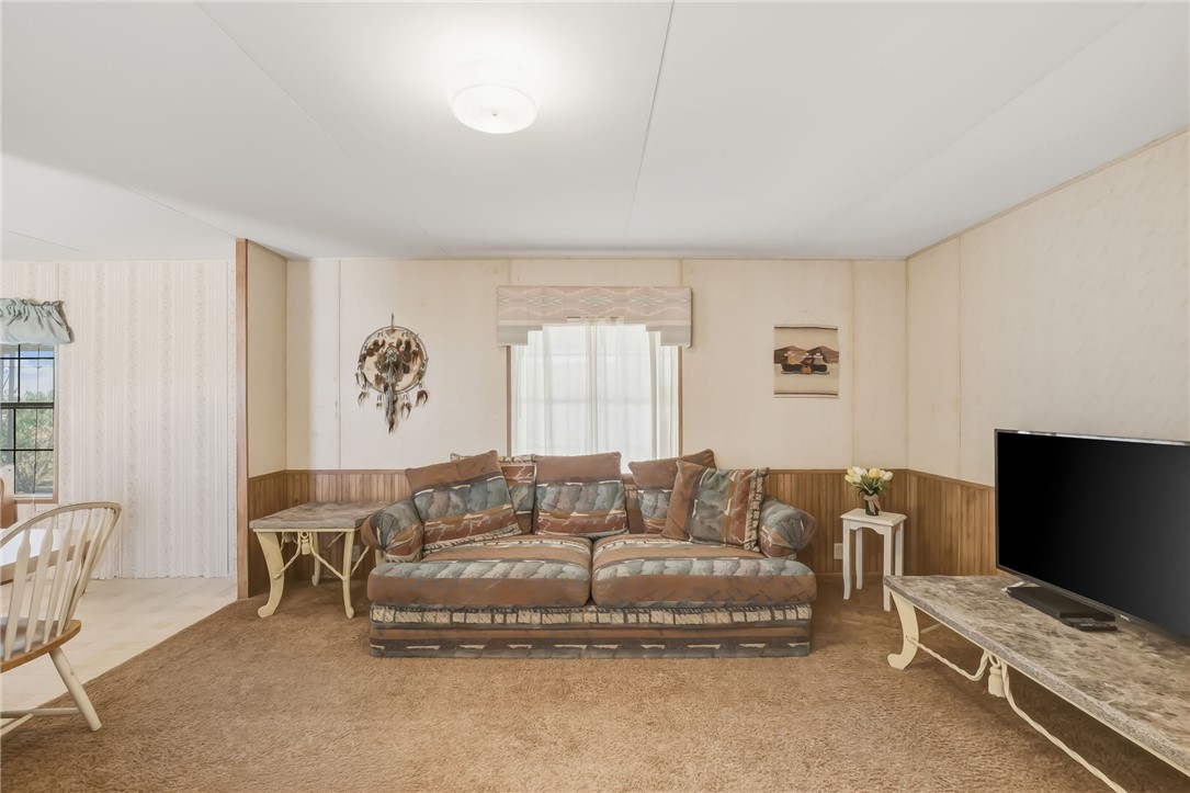 3880 Rising Sun Road Bullhead City, AZ 86442 - Photo 13 of 42 Living area featuring carpeting, wood paneling, and a flush-mount ceiling light