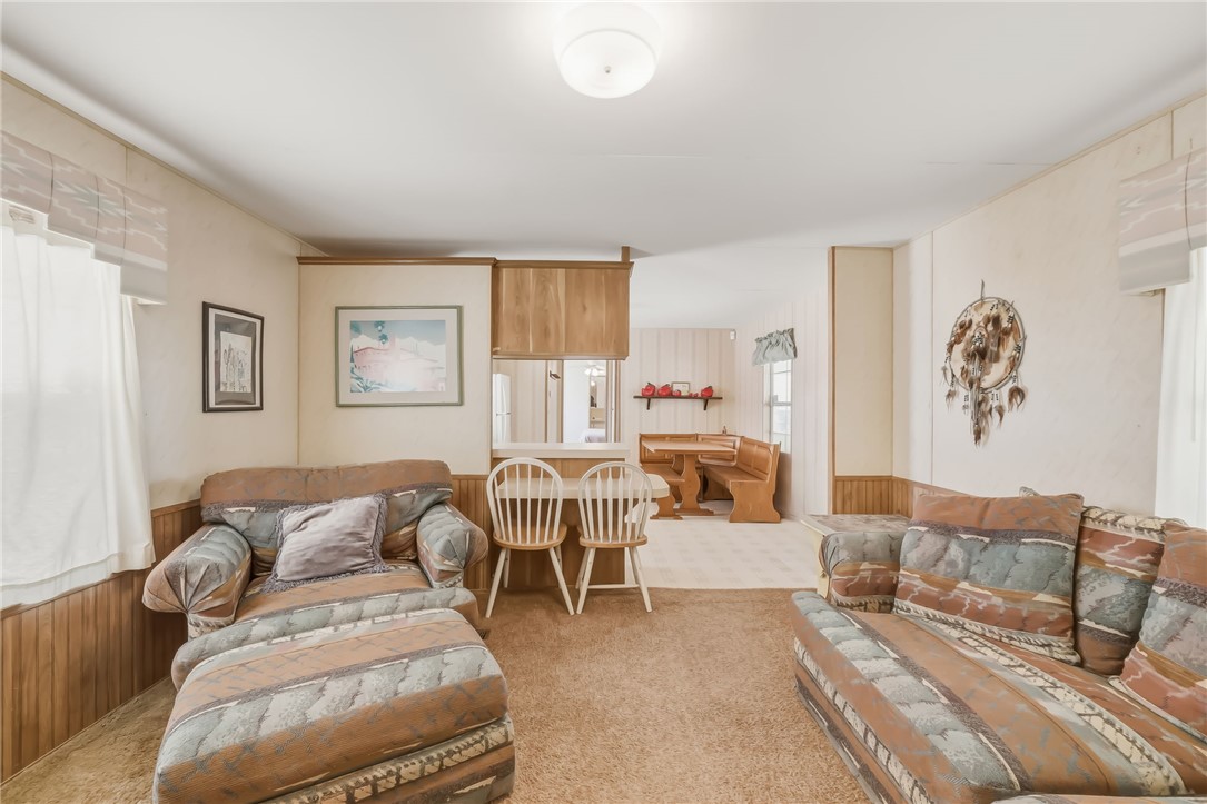 3880 Rising Sun Road Bullhead City, AZ 86442 - Photo 14 of 42 Living area featuring wood-finish paneling, overhead lighting, and a pass-through opening to an adjacent space