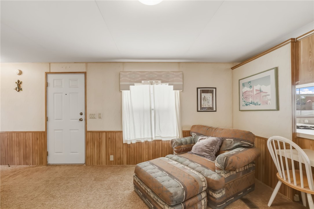 3880 Rising Sun Road Bullhead City, AZ 86442 - Photo 15 of 42 Living area featuring wood-finish paneling, light-toned walls, and a white paneled door