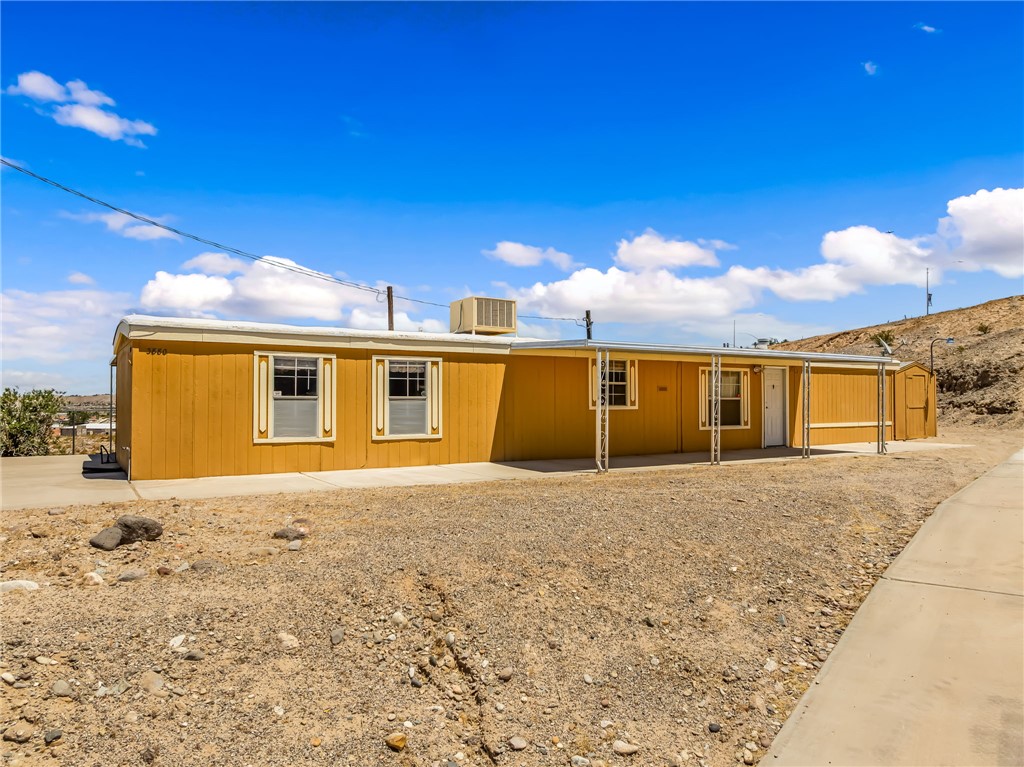 3880 Rising Sun Road Bullhead City, AZ 86442 - Photo 2 of 42 Single-story residence featuring a mustard yellow exterior and white trim