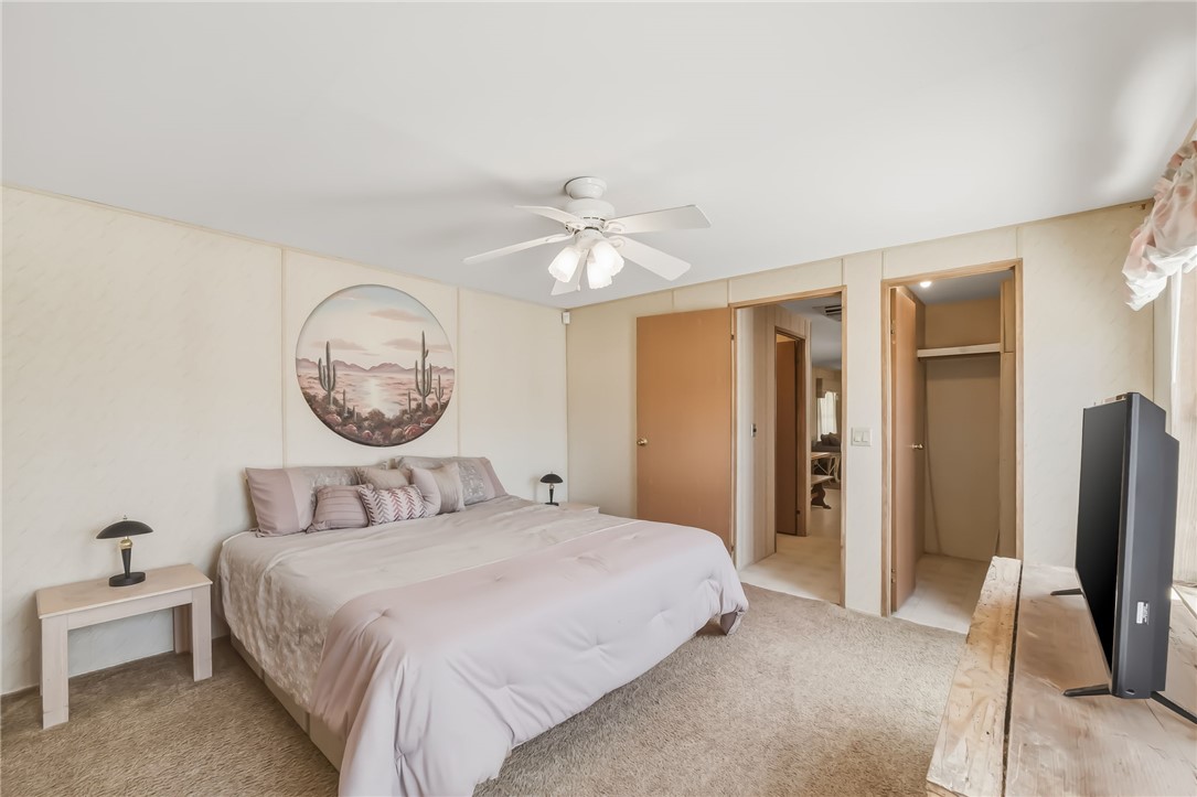 3880 Rising Sun Road Bullhead City, AZ 86442 - Photo 26 of 42 Bedroom featuring neutral-toned carpet flooring, light-colored walls, a ceiling fan with light fixture, and two interior doorways