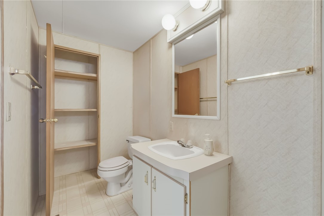 3880 Rising Sun Road Bullhead City, AZ 86442 - Photo 27 of 42 Bathroom featuring a vanity with an integrated sink, mirror with overhead lighting, and built-in shelving