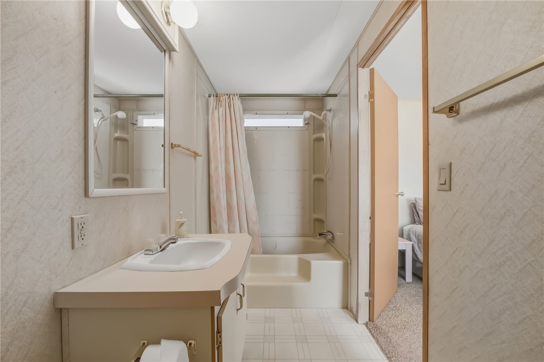 3880 Rising Sun Road Bullhead City, AZ 86442 - Photo 28 of 42 Full bathroom featuring a single vanity with an integrated sink, a mirrored medicine cabinet, overhead vanity lighting, and a combination tub and shower unit