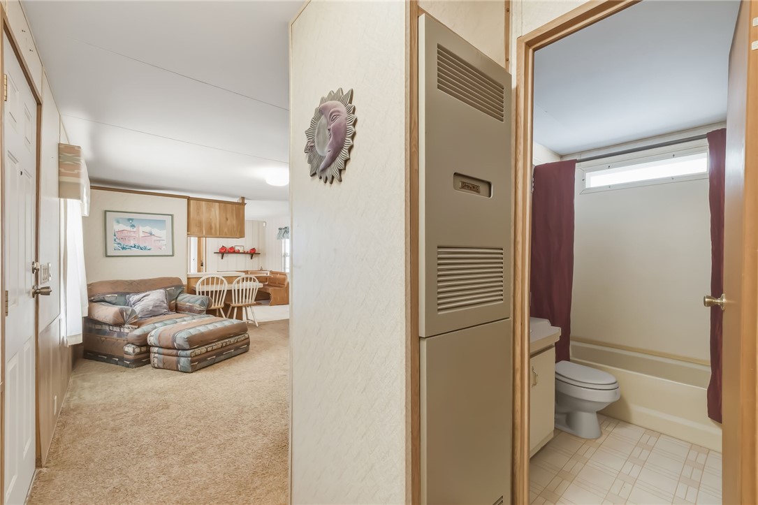 3880 Rising Sun Road Bullhead City, AZ 86442 - Photo 32 of 42 Entryway featuring a built-in utility cabinet, leading to a bathroom with a window and a tub/shower combination