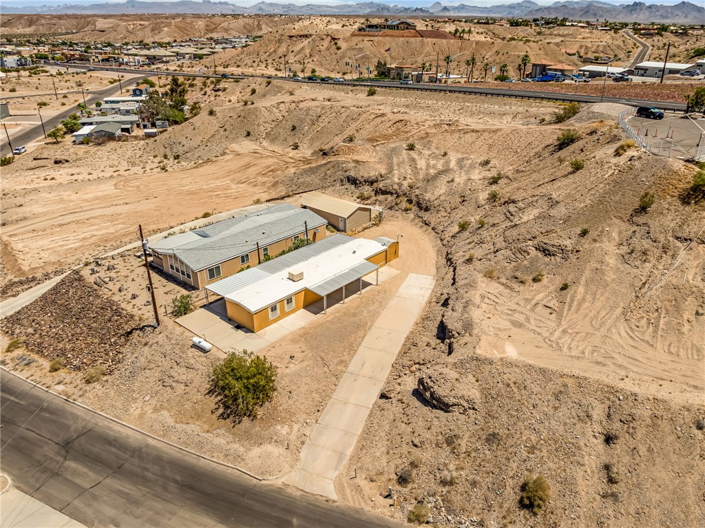 3880 Rising Sun Road Bullhead City, AZ 86442 - Photo 41 of 42 Pictured neighboring residential structures on a desert landscape lot with a detached garage