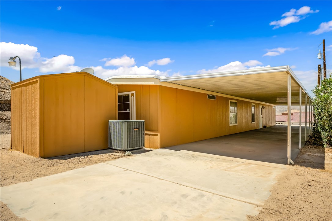 3880 Rising Sun Road Bullhead City, AZ 86442 - Photo 5 of 42 Exterior featuring an attached carport, multiple windows, and a light-colored fa?ade