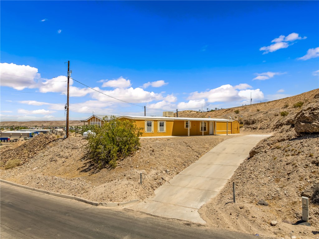 3880 Rising Sun Road Bullhead City, AZ 86442 - Photo 6 of 42 Single-story residence with yellow siding and white trim