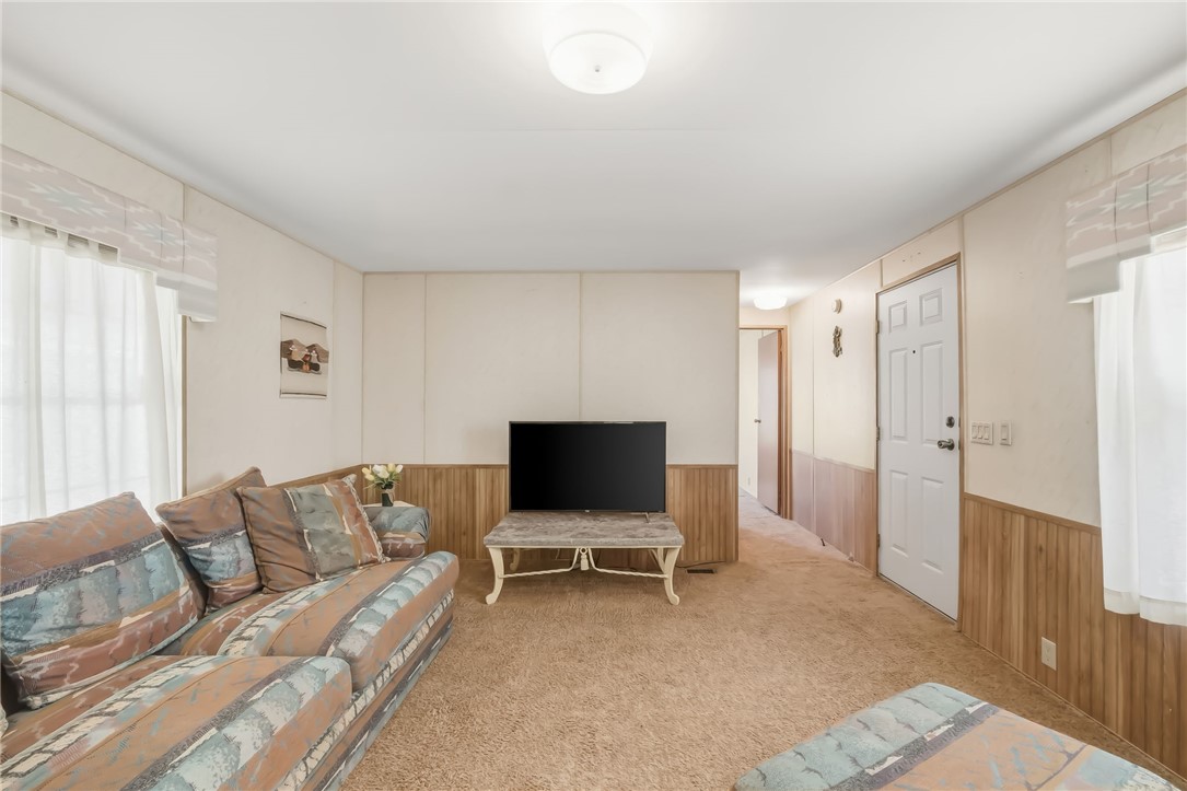 3880 Rising Sun Road Bullhead City, AZ 86442 - Photo 10 of 42 Living area featuring neutral wall tones, lower wood-finish paneling, and wall-to-wall carpeting