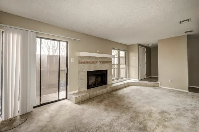 a view of an empty room with a fireplace and a window