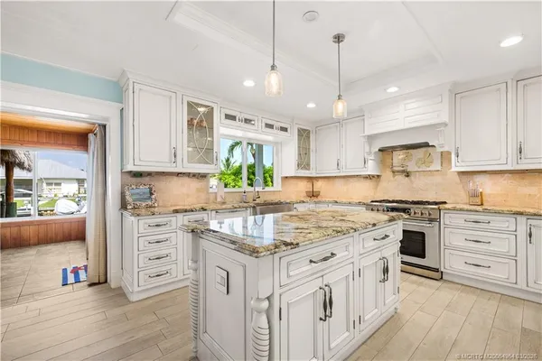 a kitchen with stainless steel appliances granite countertop a stove oven and white cabinets