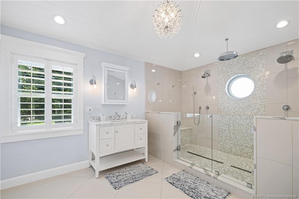 1359 Southwest Dyer Point Road Palm City, FL 34990 - Photo 21 of 55 a spacious bathroom with a granite countertop sink a toilet a mirror and a glass door shower