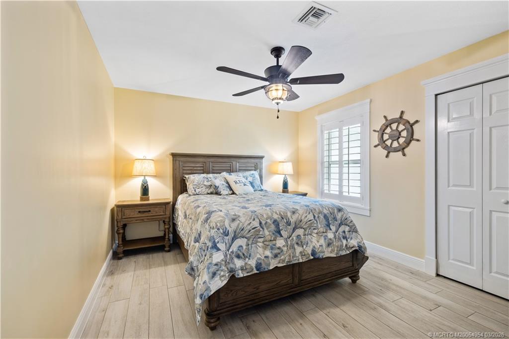 1359 Southwest Dyer Point Road Palm City, FL 34990 - Photo 26 of 55 a bedroom with a bed and wooden floor