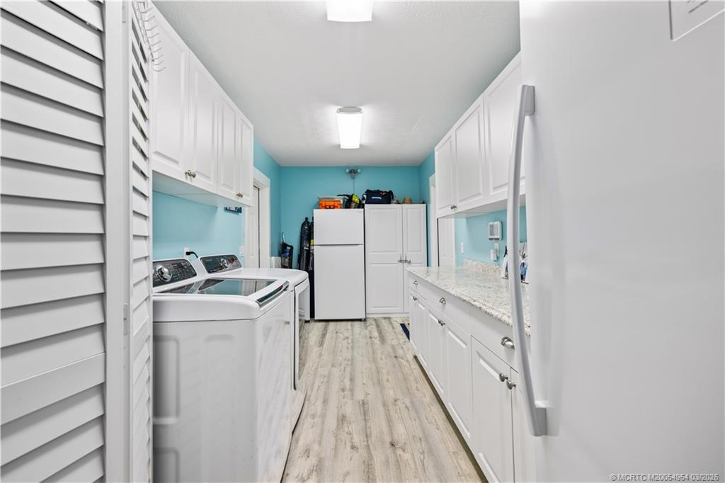 1359 Southwest Dyer Point Road Palm City, FL 34990 - Photo 30 of 55 a kitchen with white cabinets and white appliances