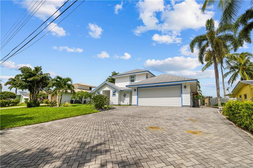 1359 Southwest Dyer Point Road Palm City, FL 34990 - Photo 52 of 55 a front view of a house with a garden and trees