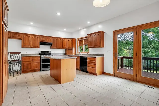 a view of a big room with windows and chandelier fan