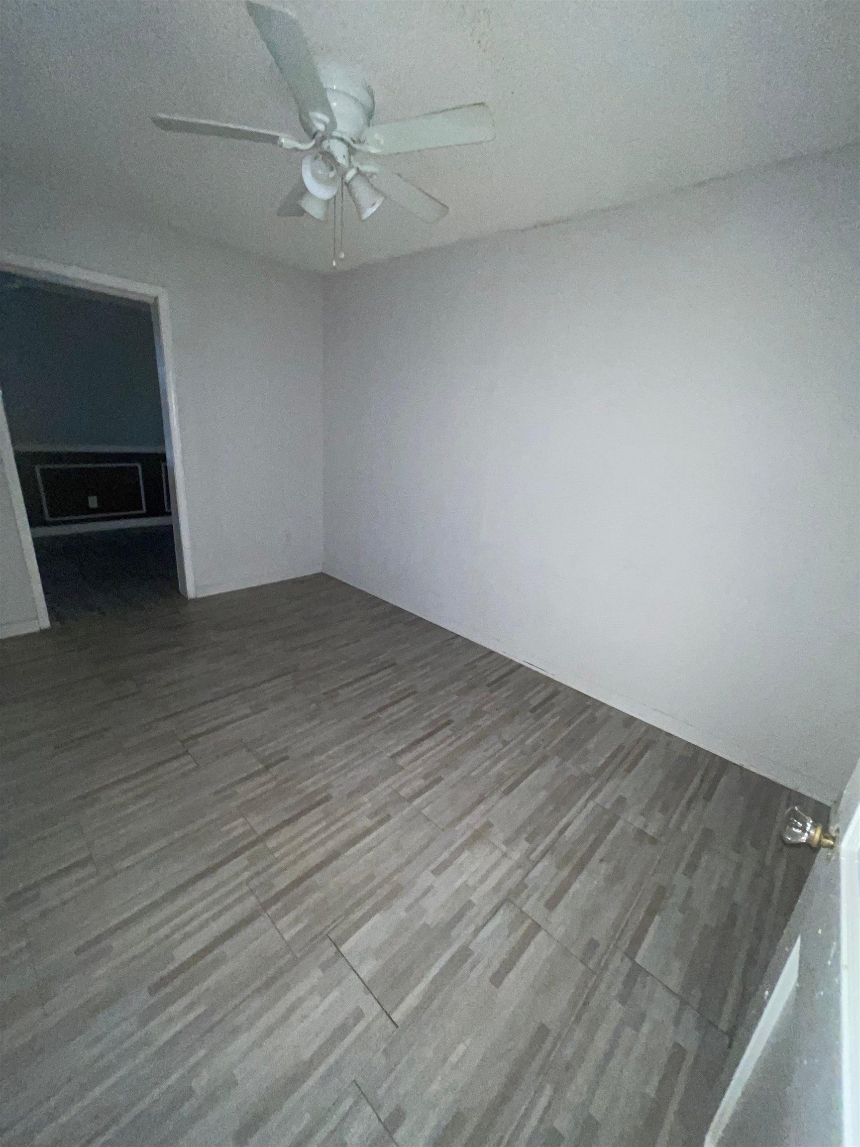 271 West Brooks Road Memphis, TN 38109 - Photo 12 of 17 Empty room with wood finished floors and a ceiling fan