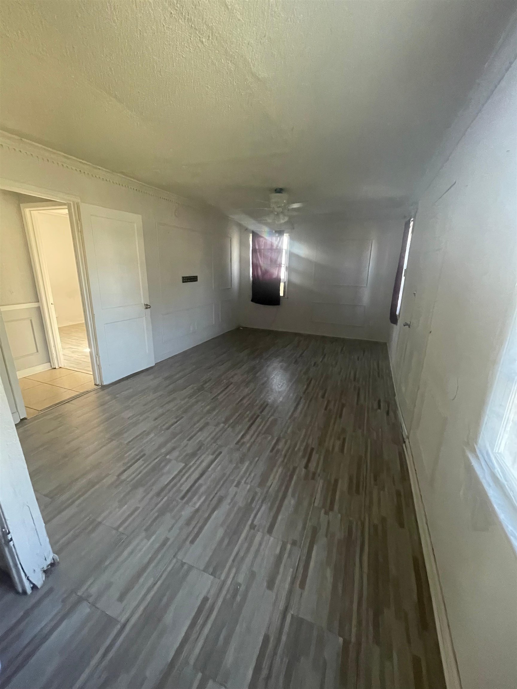 271 West Brooks Road Memphis, TN 38109 - Photo 4 of 17 Unfurnished room with dark wood-style flooring, a textured ceiling, a decorative wall, and ceiling fan