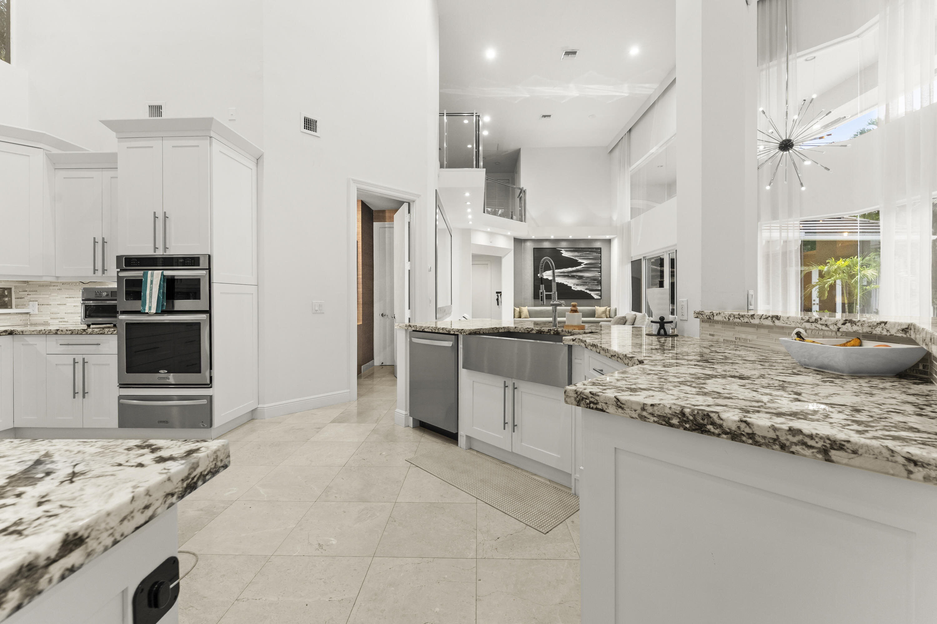 3156 Northwest 61st Street Boca Raton, FL 33496 - Photo 14 of 46 a large kitchen with kitchen island a sink stainless steel appliances and cabinets